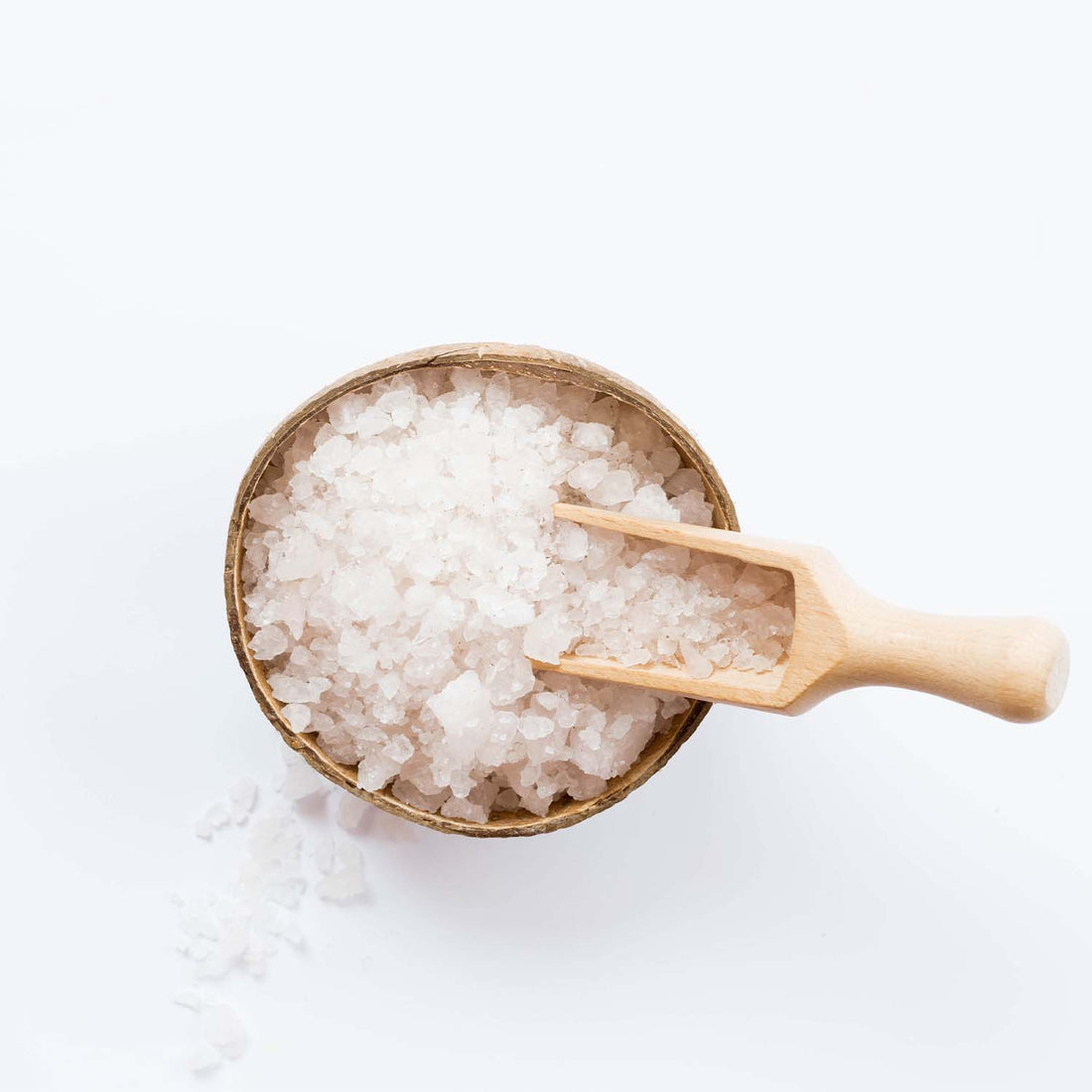 A bowl of salt with a wooden spoon on top, enhanced with Magnesium PCA for added benefits.